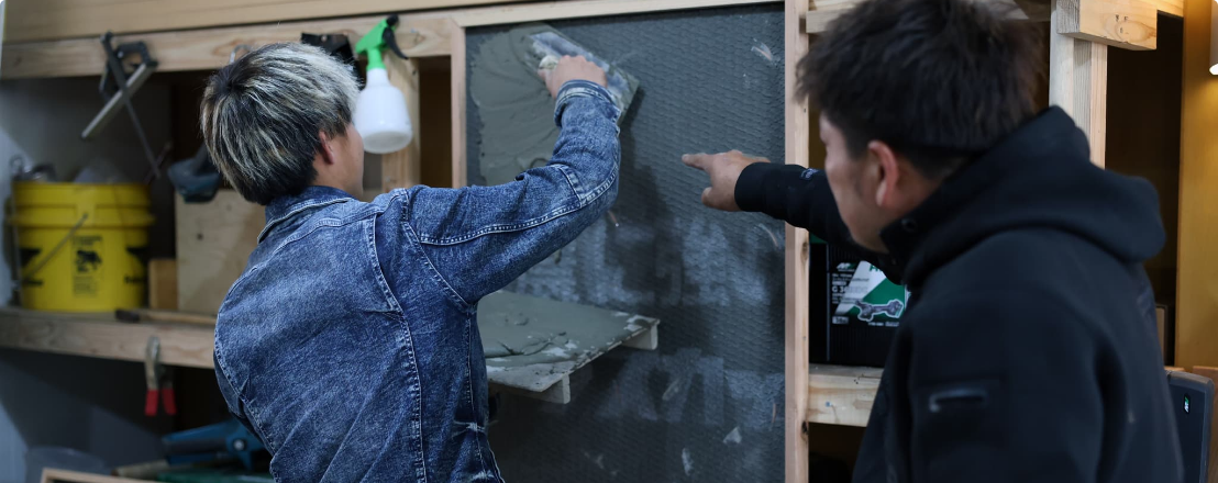 壁を塗るスタッフ