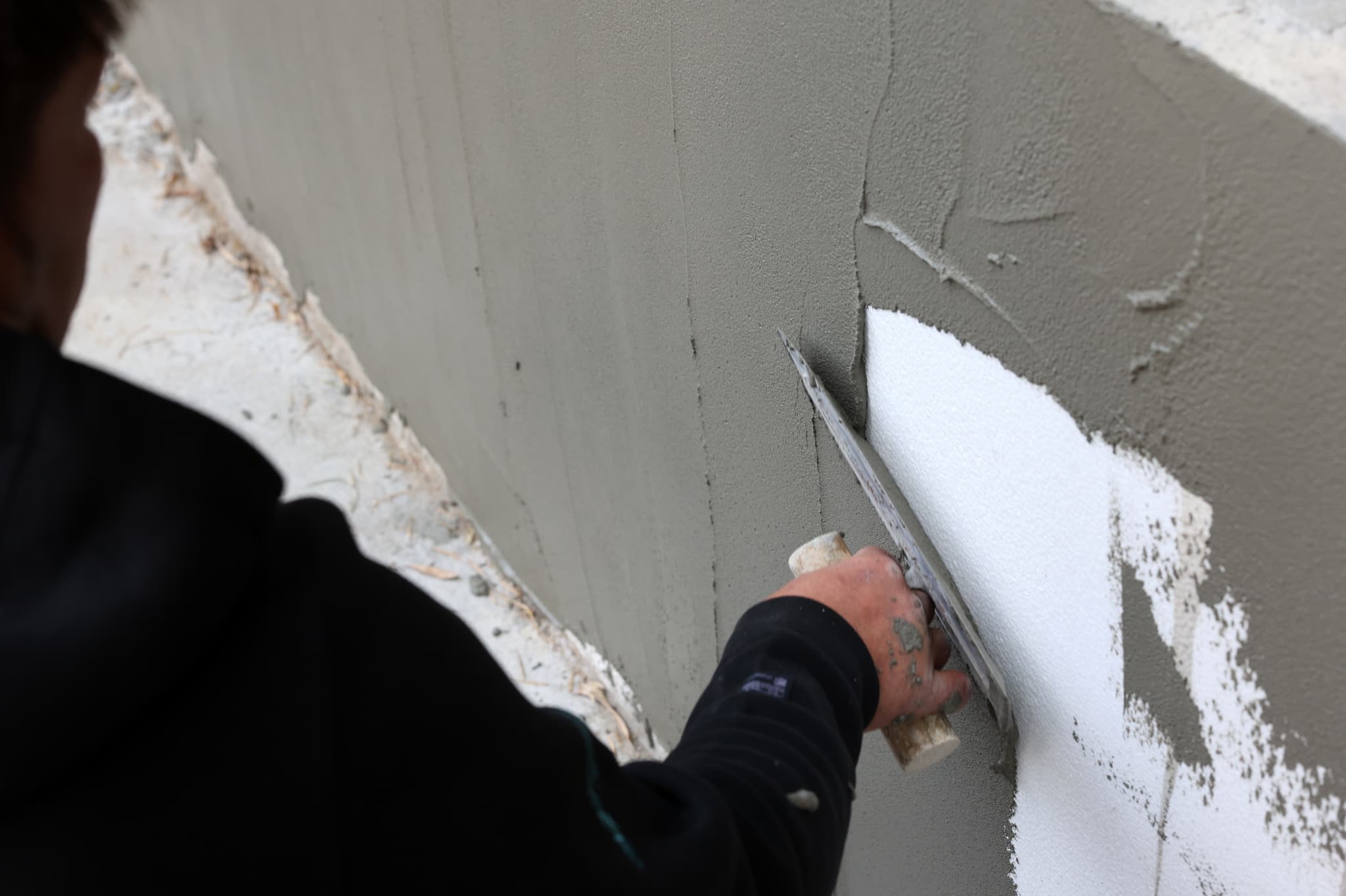 壁を塗るスタッフ