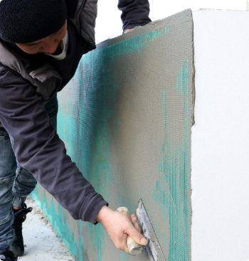 壁を塗るスタッフ