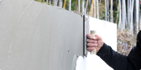 壁を塗るスタッフ